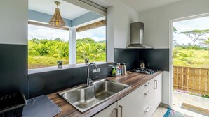 Una cucina moderna con un'ampia finestra, lavello in acciaio inossidabile e piano di lavoro in legno.
