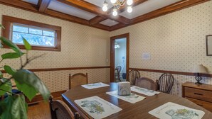 Ein Esszimmer mit Holztisch, Stühlen und einem Fenster.