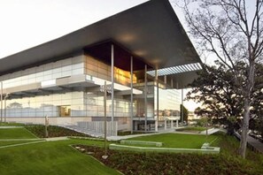 Un bâtiment moderne doté d’un toit plat, de grandes fenêtres en verre et d’une pelouse bien entretenue.