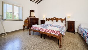 A bedroom with a wooden bed, a dresser, a chair, and a window. - Room 'Camera 1 - Del Ponti' with Shared Garden and Wi-Fi (Casa Paduletto)
