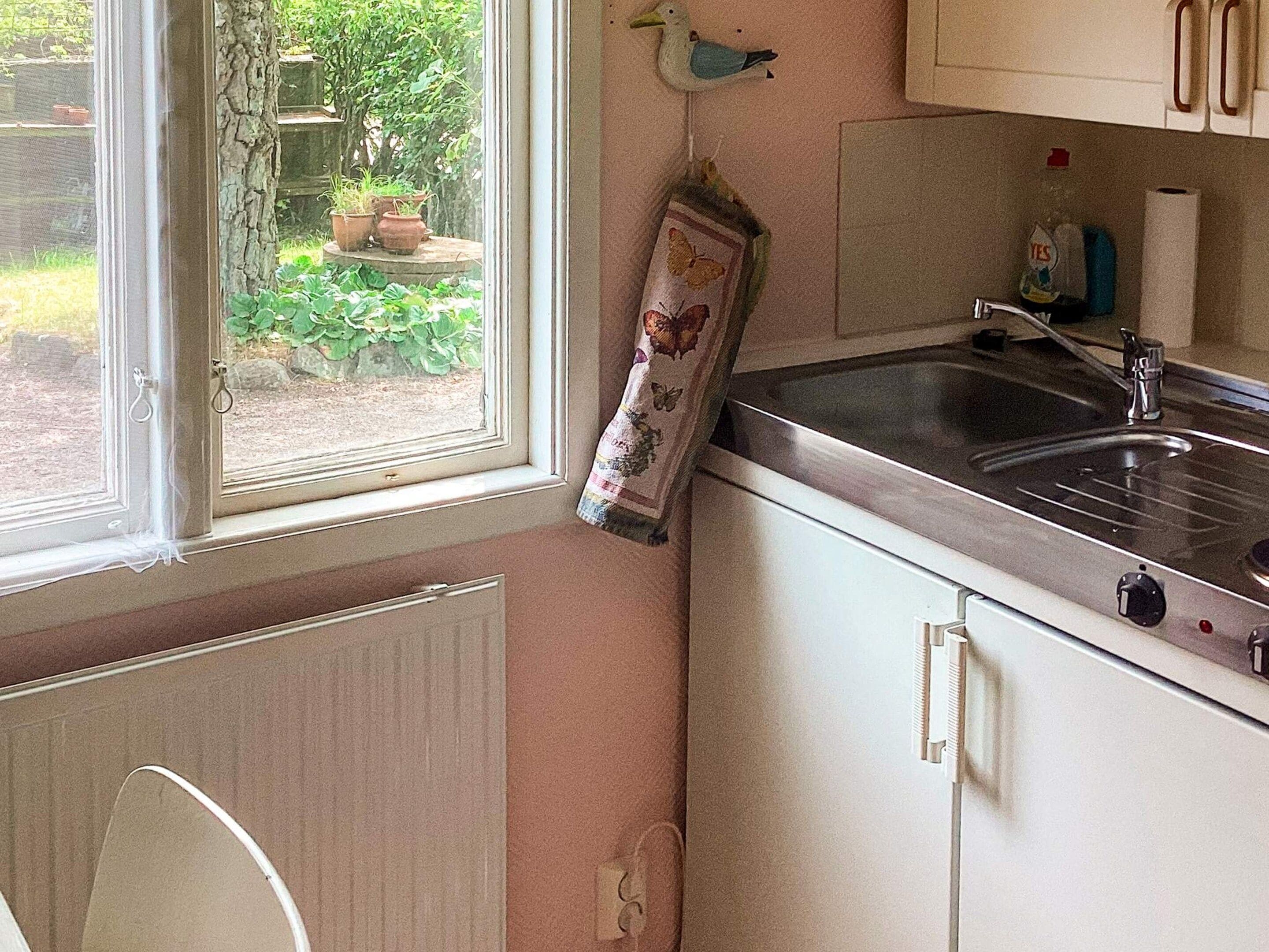 A kitchen with a window, a sink, and cabinets.
