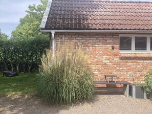 A brick house with a tiled roof, a window, and a bench outside. - 4 Person Holiday Home in Steninge (Steninge)