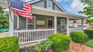 A two-story house with a porch, a sign reading "Tattoo Shop," and an American flag. - Family & Friends - Fun In Franklin (Franklin)