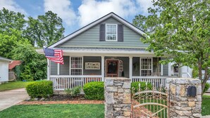A two-story house with a porch, a stone gate, and an American flag. - Family & Friends - Fun In Franklin (Franklin)