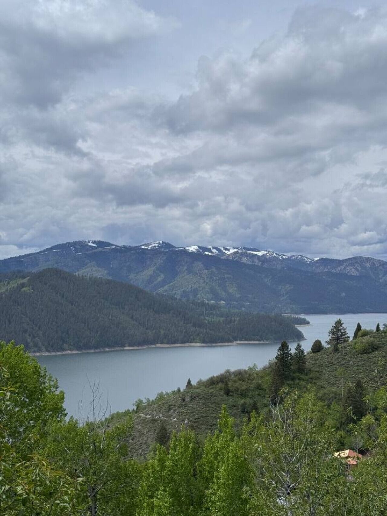 A mountainous landscape with a lake and forested area.