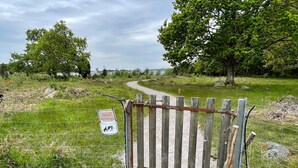 A gravel path leading through a fenced area with a wooden gate. - 4 Star Holiday Home in Karlskrona (Hasslö)