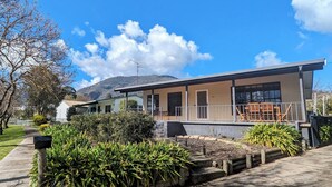 A modern two-story building with a flat roof, large windows, and a balcony. - Cupie’s Cabin (Talbingo)