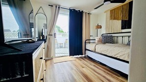 Une chambre à coucher avec un lit, un bureau et une fenêtre avec des rideaux.