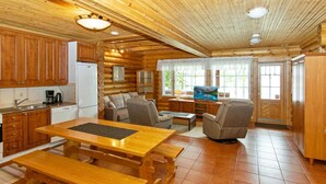 Ein rustikales Holzhaus-Interieur mit Küche, Essbereich und Wohnzimmer.