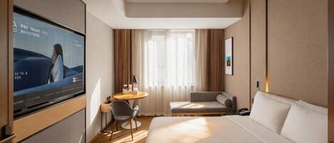 A hotel room with a bed, a desk, a chair, a TV, and a window with curtains.