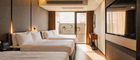 A hotel room with two beds, a TV, a desk, and a balcony with a view.