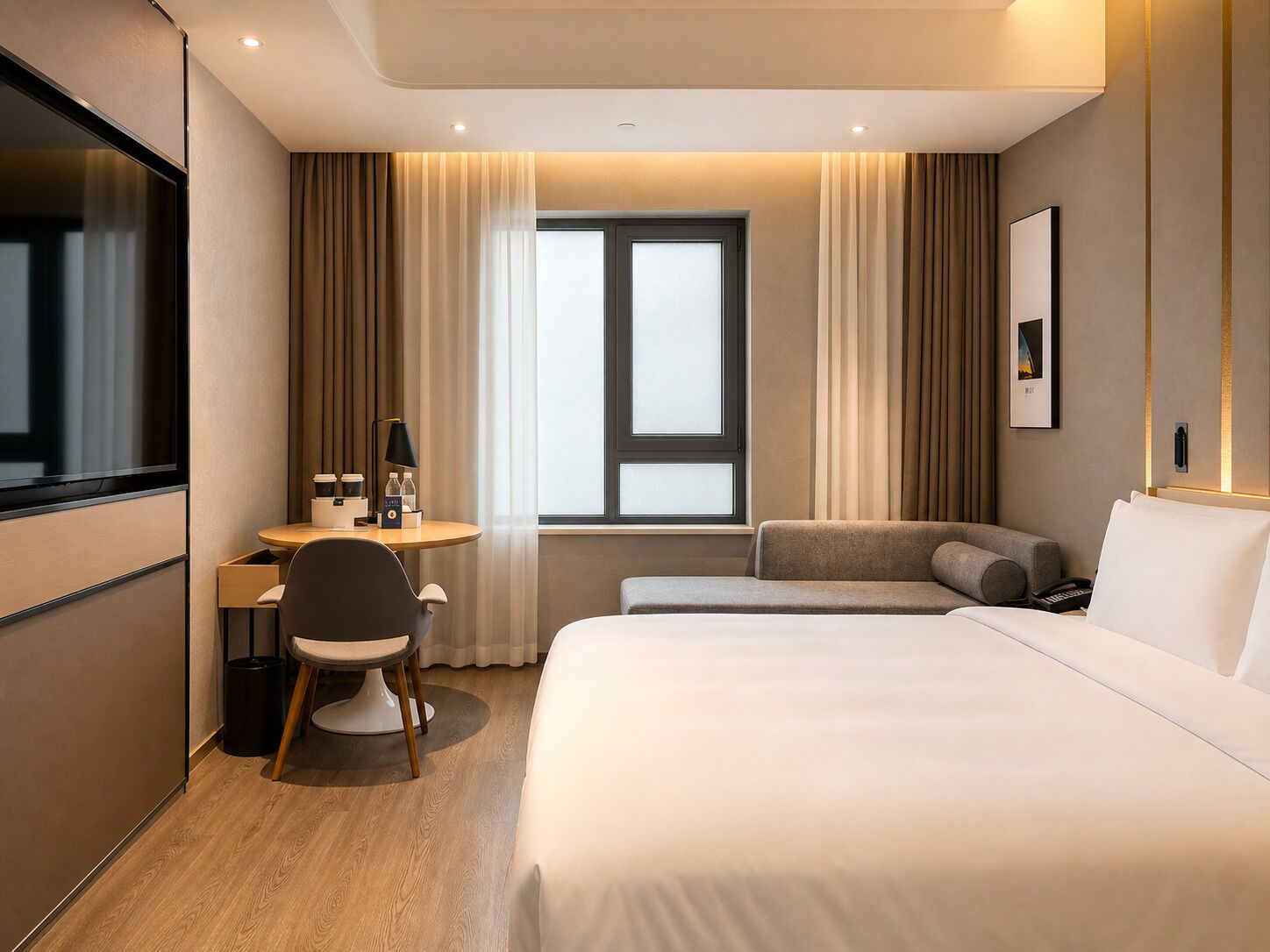 Una habitación de hotel con cama, escritorio con silla, televisión y ventana con cortinas.