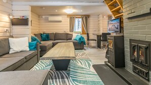 Un salon confortable avec un canapé, une table basse et une cheminée.