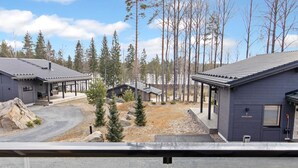 A modern building complex with multiple cabins, a covered outdoor seating area, and a gravel driveway.