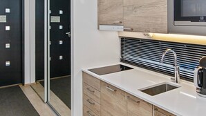 A modern kitchen with a double sink, stainless steel faucet, and a microwave above the counter.