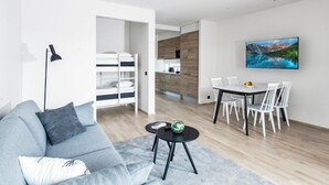 A modern living room with a sofa, a coffee table, and a TV mounted on the wall.