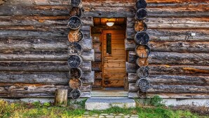 A rustic log cabin with a wooden door and a framed picture above it. - Rukan pilvimaja by Interhome (Kuusamo)