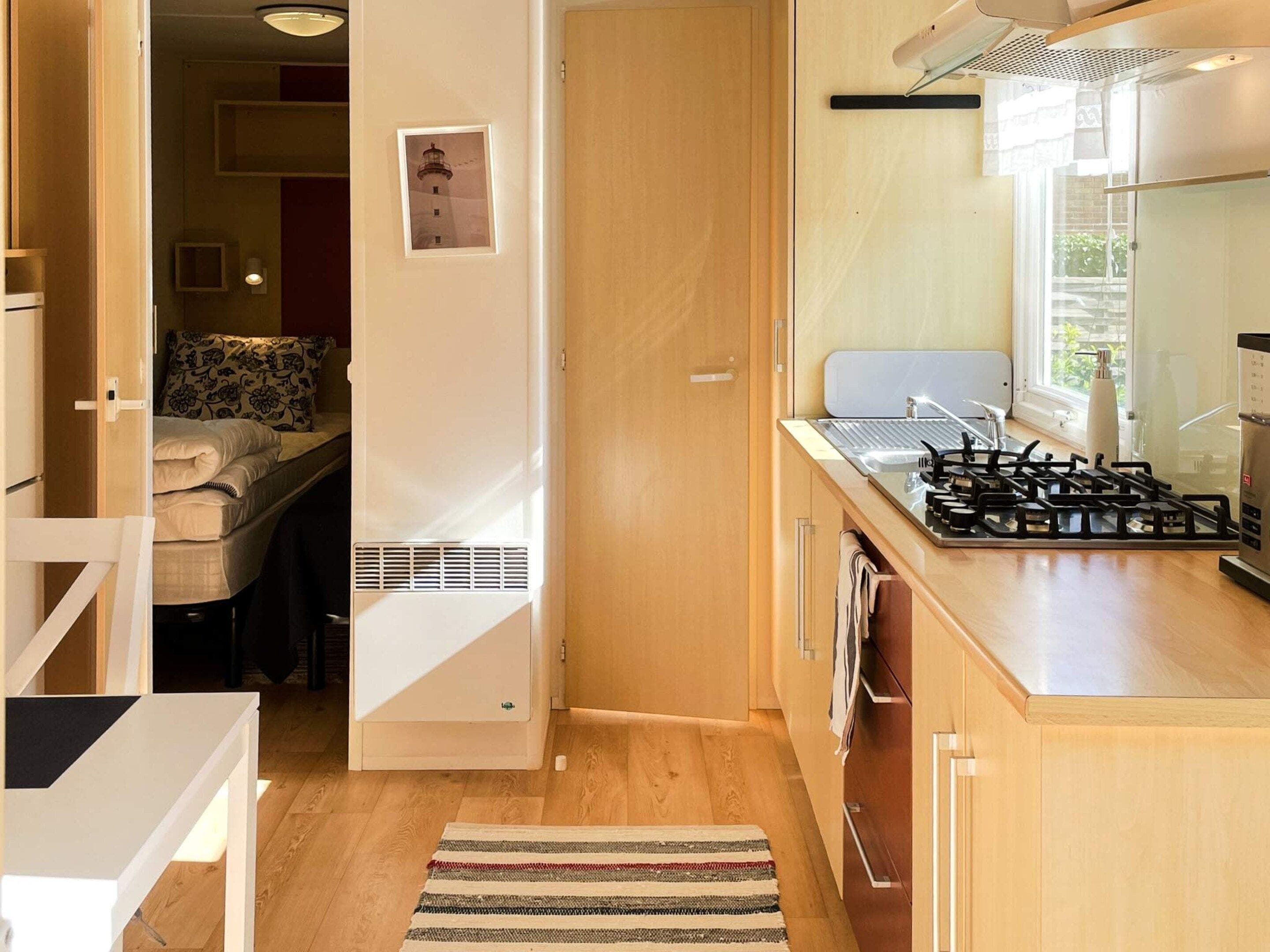 A compact kitchen with a gas stove, a built-in oven, and a window providing natural light.
