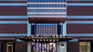 A hotel entrance with a modern design, featuring a prominent sign and a revolving door. - Atour Light Hotel on the Bund Nanjing Road (Shanghái)