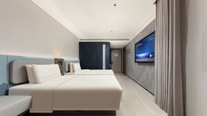 A modern hotel room with a large bed, a sofa, a flat-screen TV mounted on the wall, and a wooden floor. - Atour Light Hotel on the Bund Nanjing Road (Shanghái)