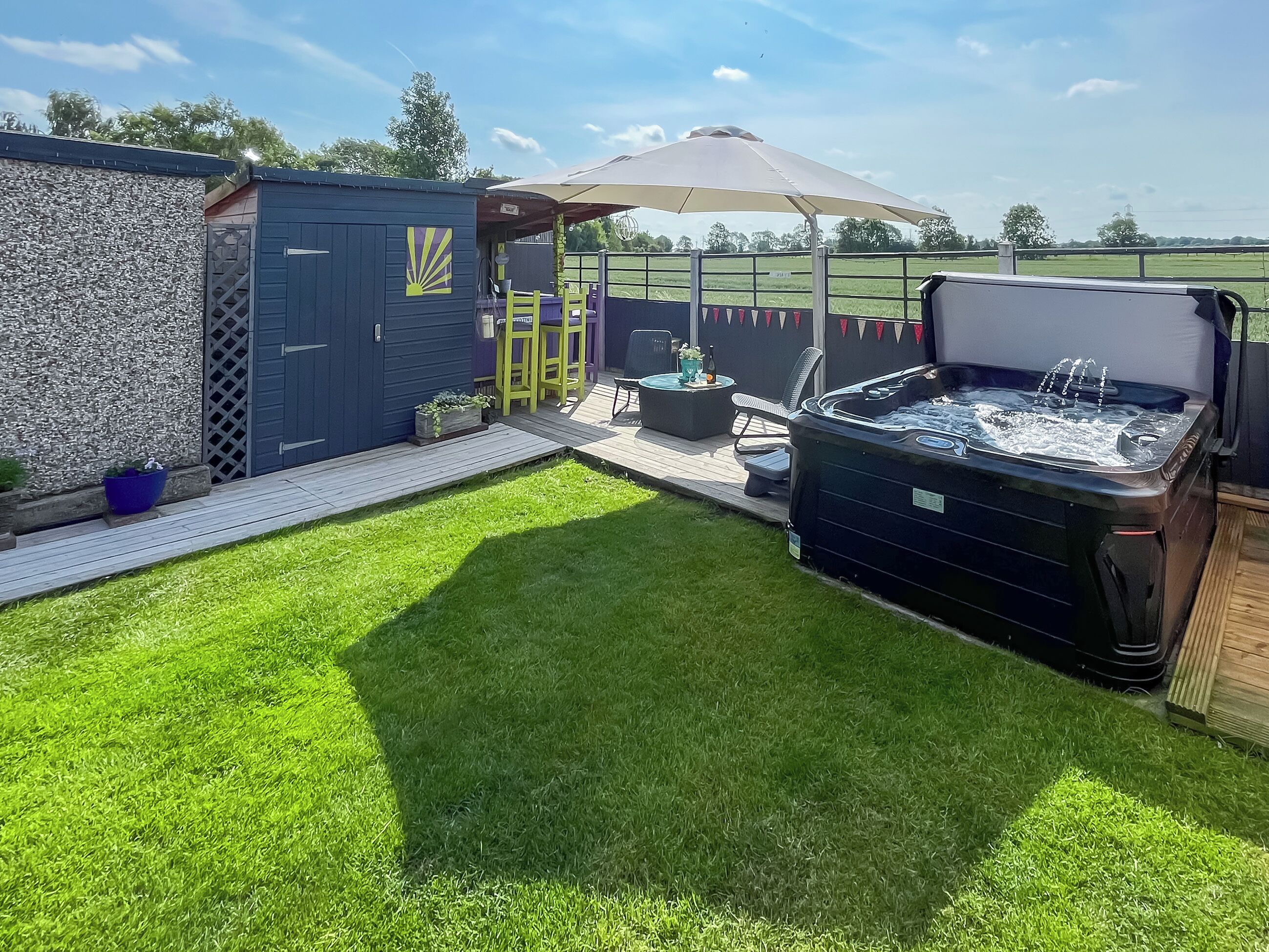 Un jardin avec un jacuzzi, du mobilier d’extérieur et une pergola.
