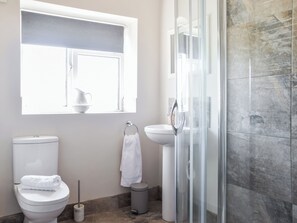 A bathroom with a toilet, sink, and glass shower enclosure. - 1 bedroom accommodation in Bakewell (Bakewell)