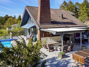 A house with a swimming pool, outdoor seating, and a covered patio area. - 5 Star Holiday Home in Stromstad (Stromstad)