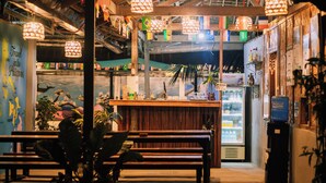 A cozy restaurant with wooden benches, a counter, and a refrigerator.