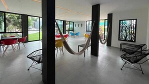 A spacious indoor area with large windows, a hammock, and modern furniture. - Serenity Loft for relaxation with pool in Oaxtepec (Oaxtepec)