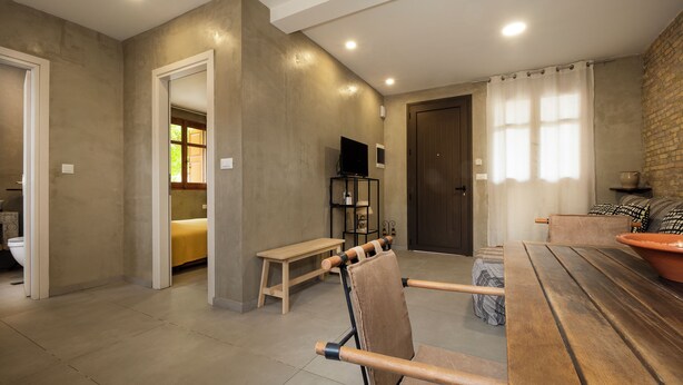 A modern living room with a wooden table, a bench, and a sofa. - Rianou Apartment (Chania)