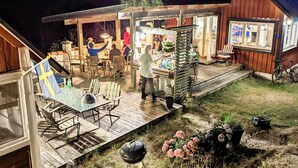 A wooden deck with outdoor seating and a barbecue grill. - 5 Person Holiday Home in Ingaro (Ingaro)