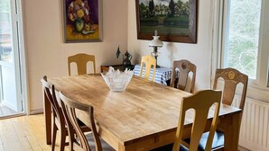 A dining room with a wooden table, six chairs, a vase, and two paintings on the wall. - 5 Person Holiday Home in Ingaro (Ingaro)