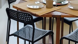 A dining area with a wooden table, black chairs, and a blue sofa in the background. - Preciosas Vistas a Catedral (Seville)