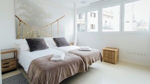 A modern hotel room with two beds, a large window, and a view of the city. - Preciosas Vistas a Catedral (Seville)