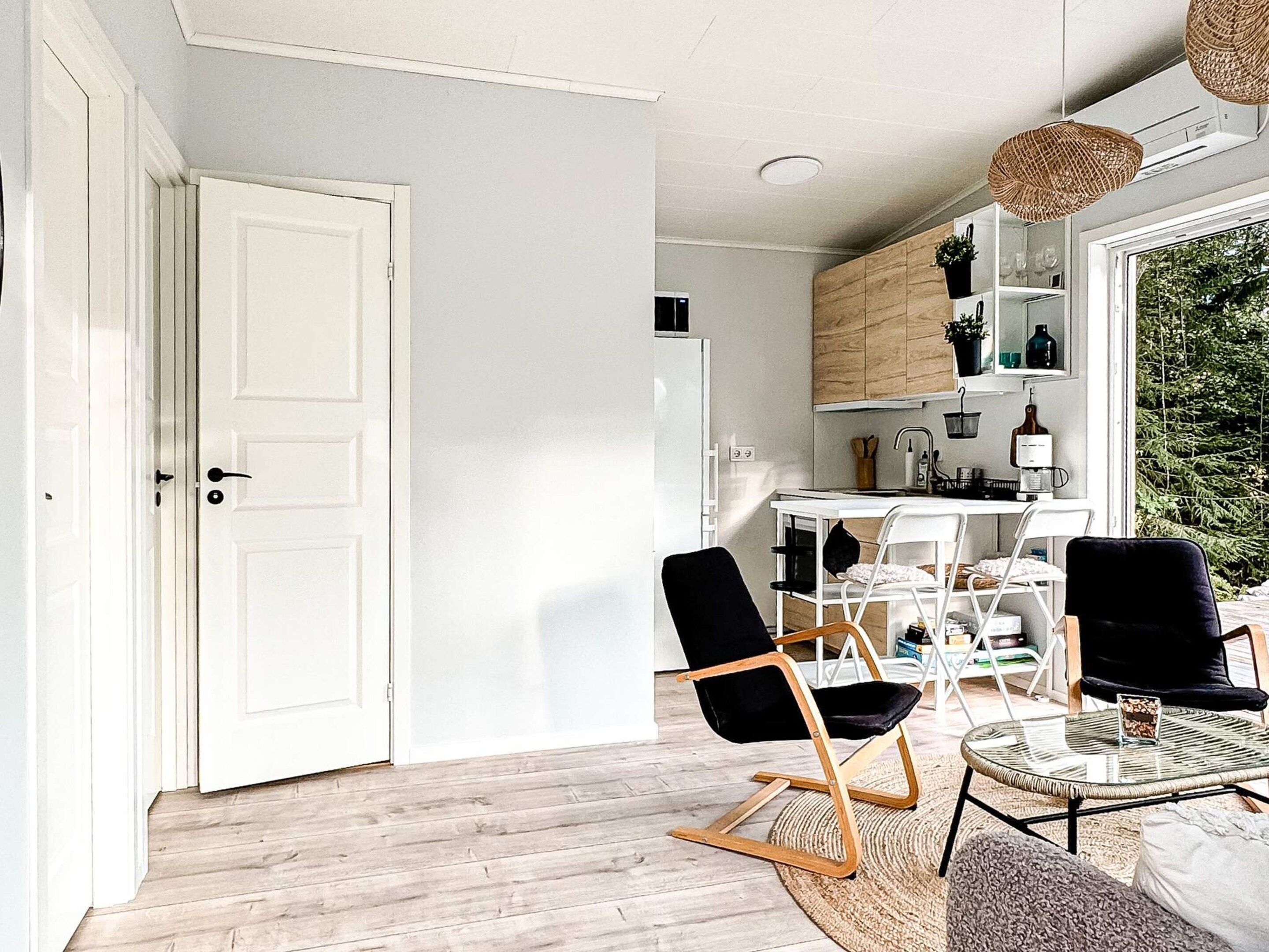 A modern kitchen with white cabinets, a dining table, and chairs.