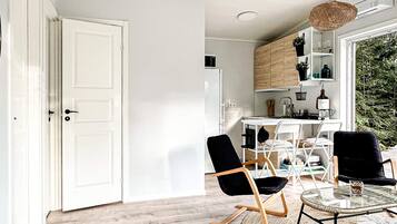 A modern kitchen with white cabinets, a dining table, and chairs.