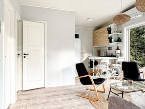 Une cuisine moderne avec des meubles blancs, une table à manger et des chaises.