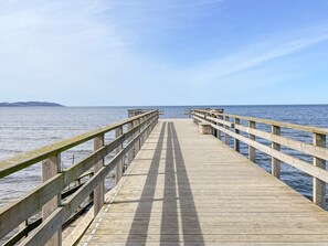 A wooden pier extending into calm waters with a clear sky above. - 2 Person Holiday Home in Bastad (Bastad)