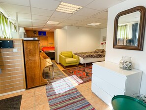 Una habitación de hotel con una cama, una silla, un escritorio y un espejo.