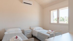 A bedroom with two beds, a desk, and a chair. - Lamia Flora con Piscina Privata (Latiano)