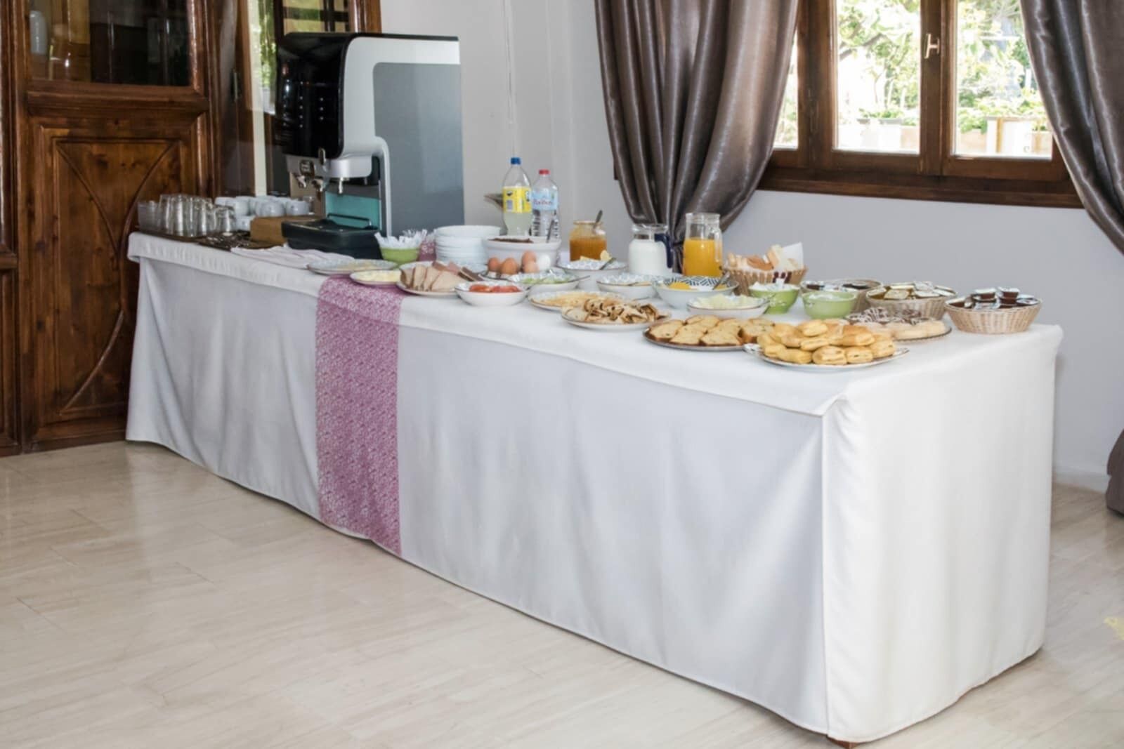 Ein reichhaltiges Frühstücksbuffet mit verschiedenen Speisen und einer Kaffeemaschine.