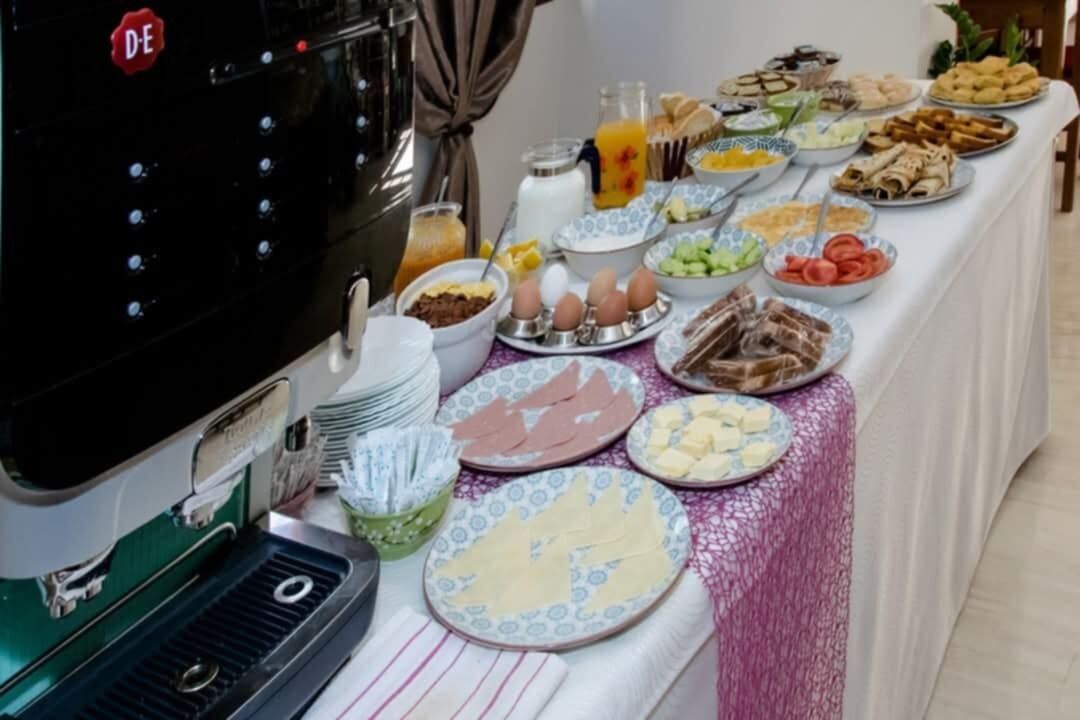 A buffet table with various food items and a coffee machine.