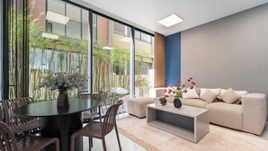 A modern living room with a round table, chairs, a sofa, and a coffee table. - The Global City - Jenny Residences (Ho Chi Minh City)