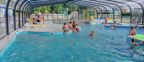 Una piscina cubierta, una piscina al aire libre de temporada, tumbonas