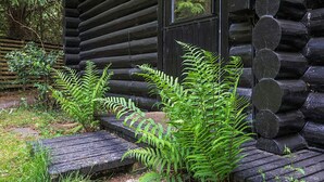 A log cabin with a wooden porch and steps leading up to the entrance.