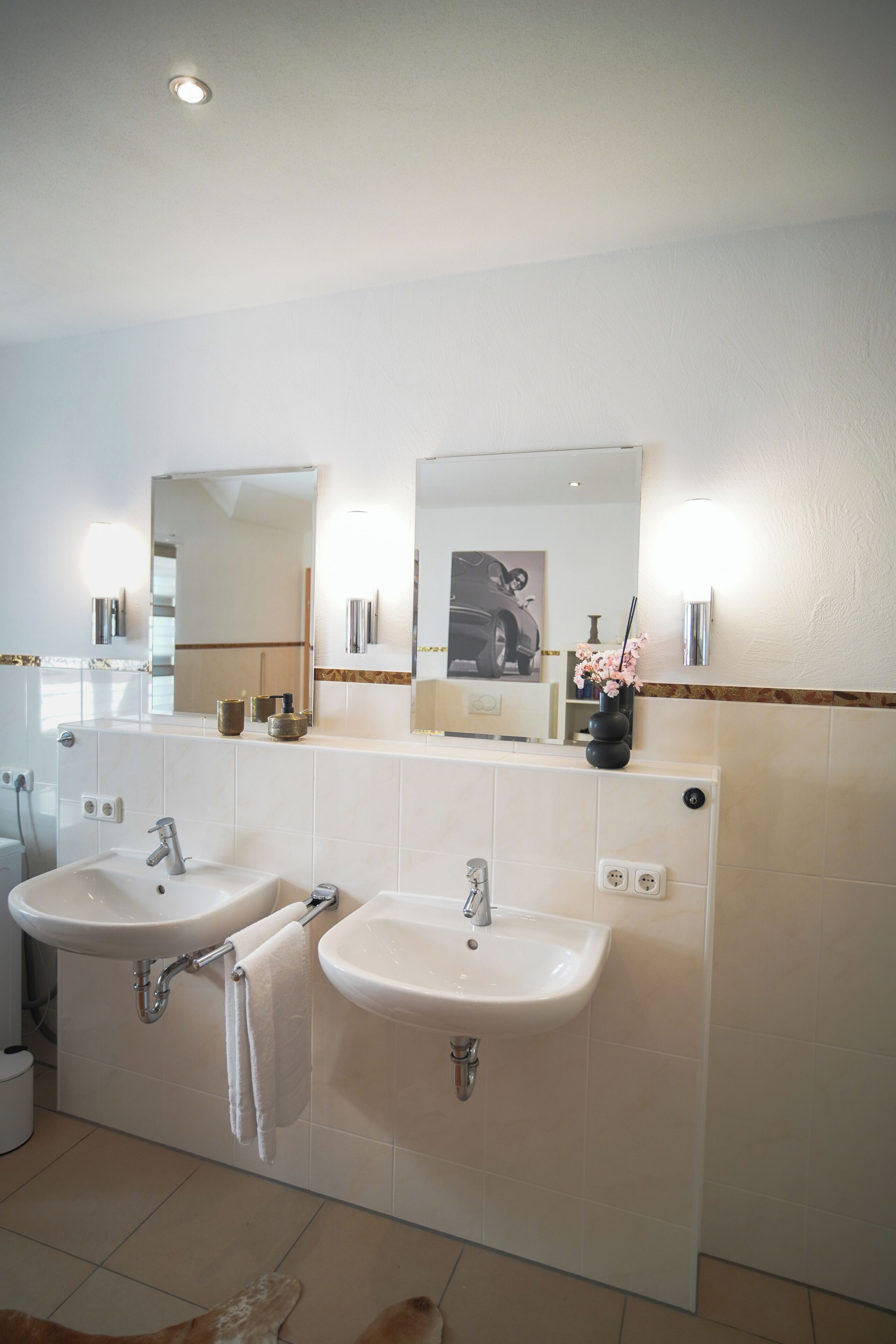 A bathroom with two sinks, a mirror, and a towel rack.