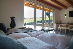 Une chambre avec un grand lit, un vase et une vue sur un patio avec une table et des chaises.