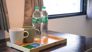A tray with two water bottles and two mugs on a wooden table near a window. - Yǒu mǒu hostel (Tainan)