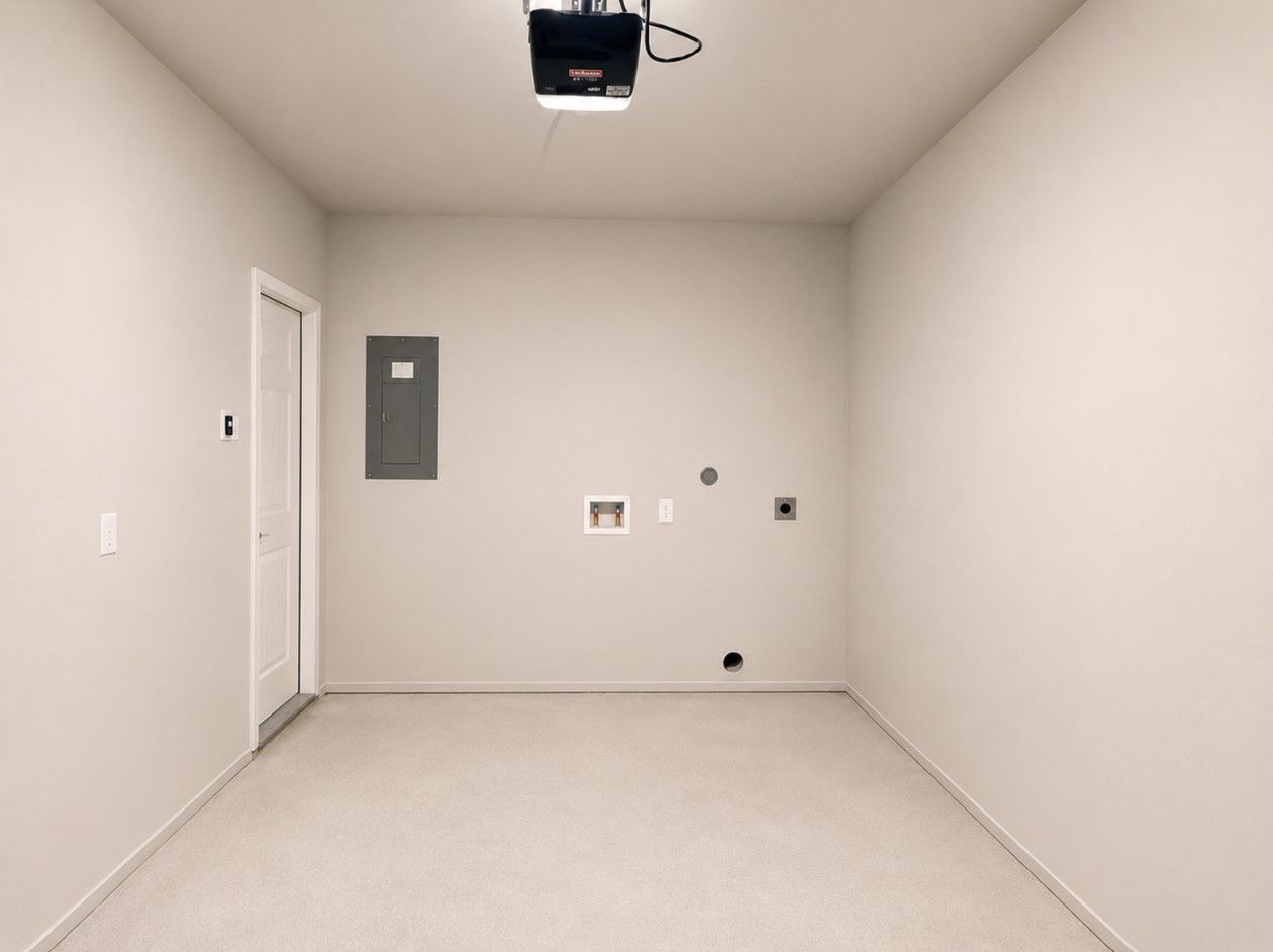 Ein schlichter Raum mit einer Tür, einem Projektor und einem kleinen, an der Wand befestigten Schrank.