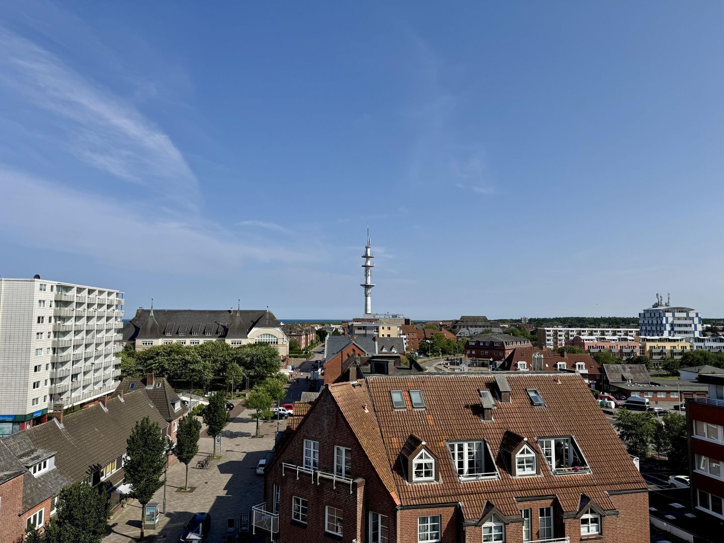 A residential area with a prominent tower, a mix of modern and traditional architecture, and a clear sky.